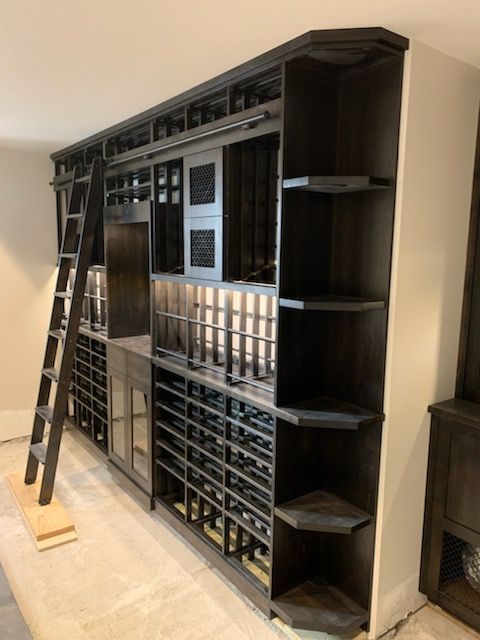 Large black wooden shelving unit with many small compartments in a room, viewed at an angle