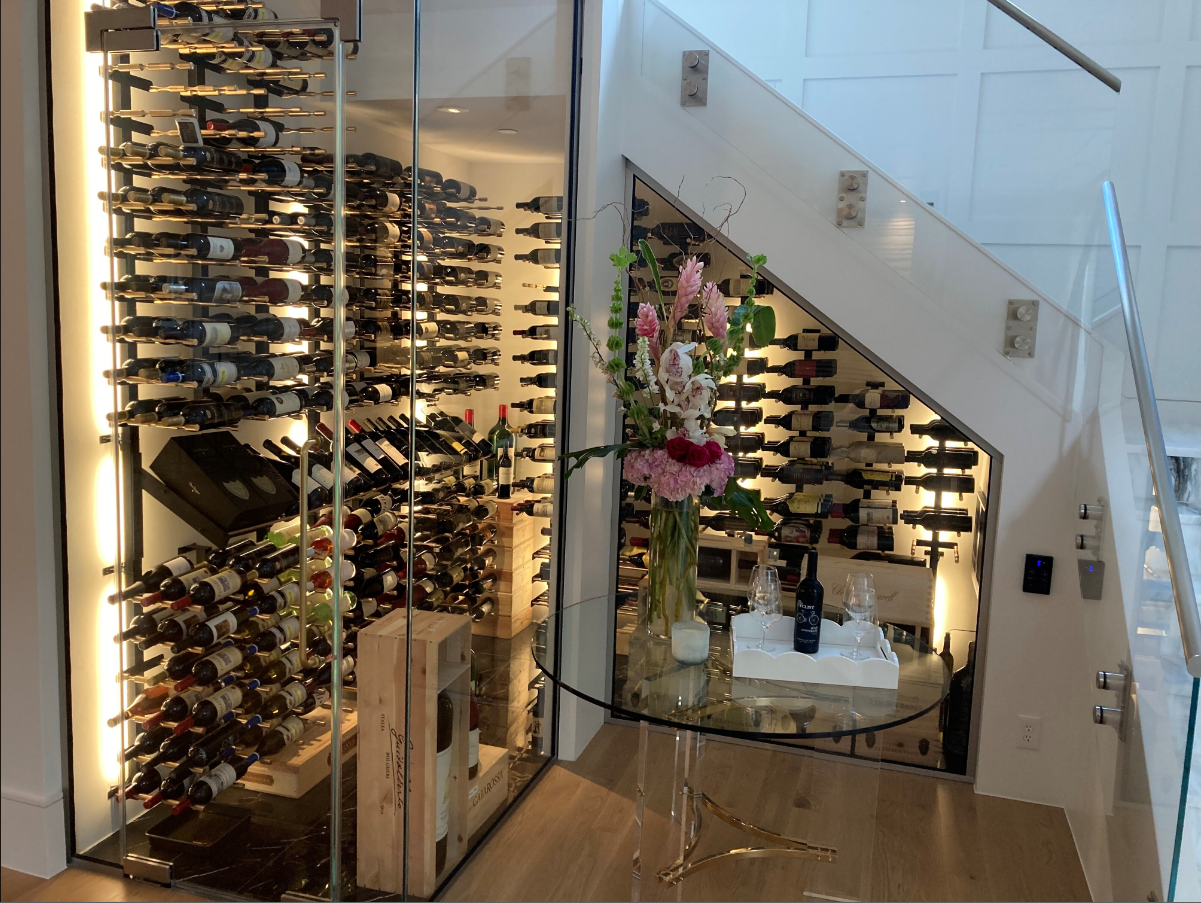 Modern wine cellar with glass walls, floor-to-ceiling racks, and a circular display table with flowers