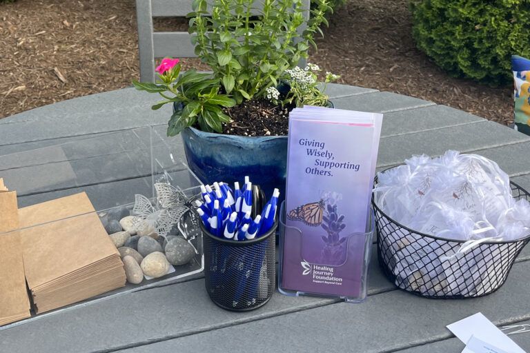 Table with craft supplies: pencils, bags, brochure, flower pot, rocks, and a basket | Lancaster PA Healing Journey Foundation