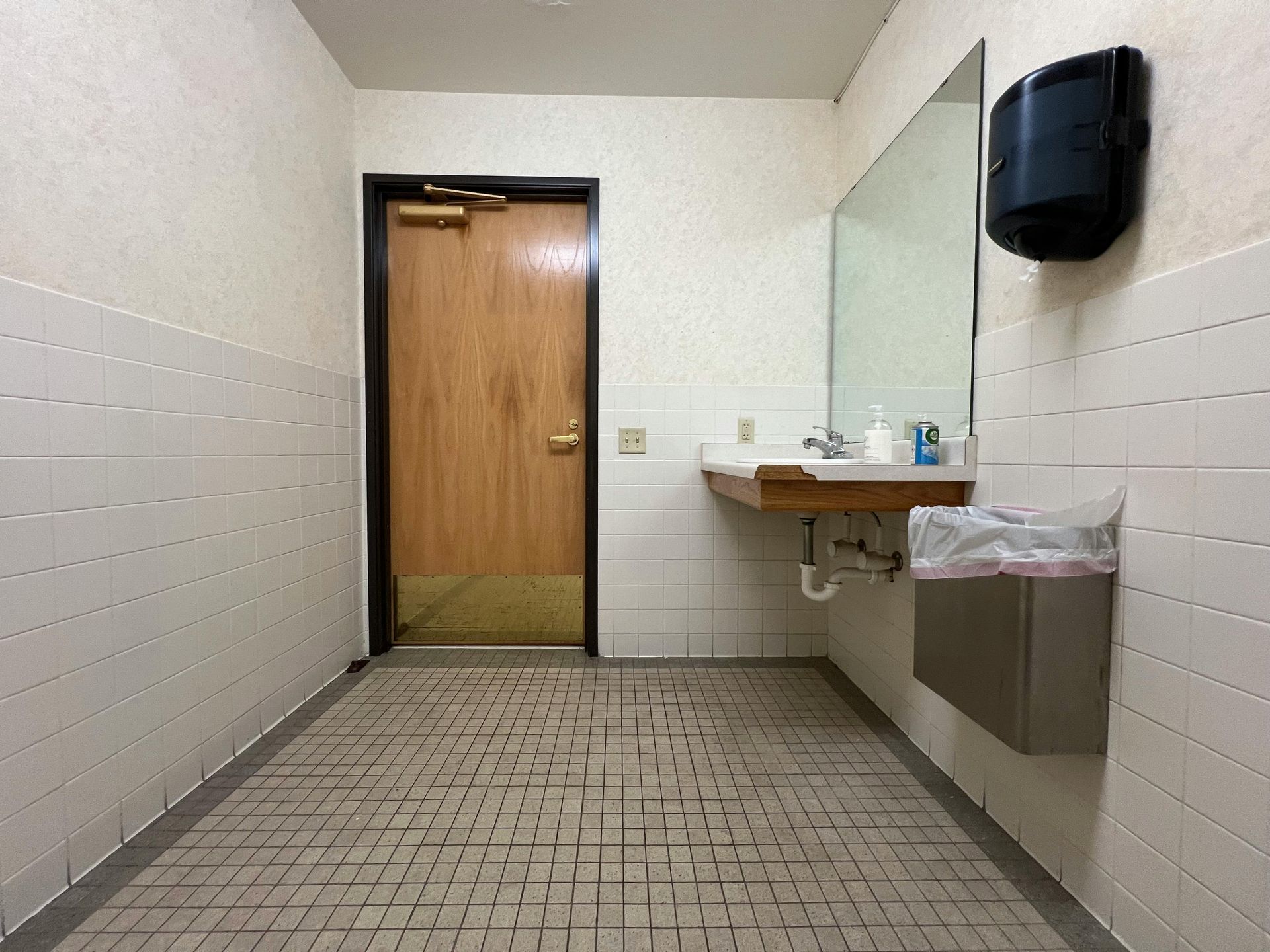A bathroom with a bathtub , sink , mirror and window.