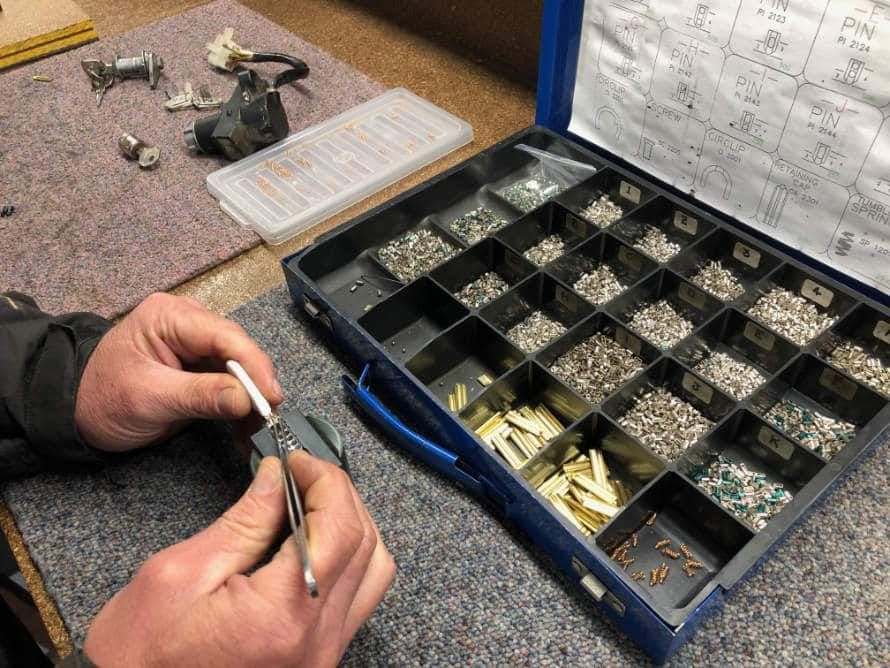 Man is Working on a Piece of Metal Next to a Box of Screws — KeyBay in Mittagong, NSW