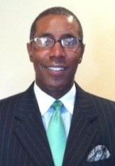 A man in a suit and tie is smiling for the camera.