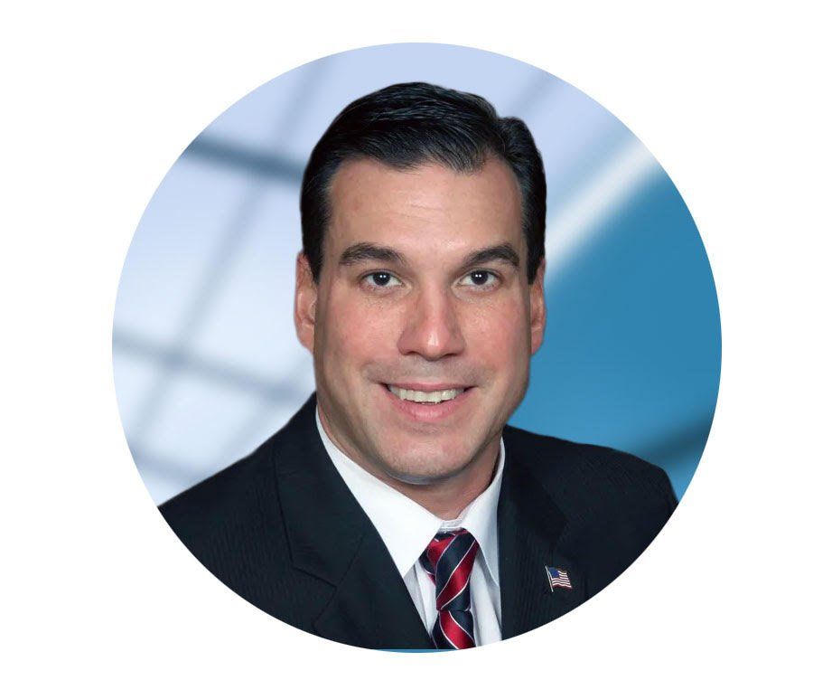 A man in a suit and tie is smiling in a circle