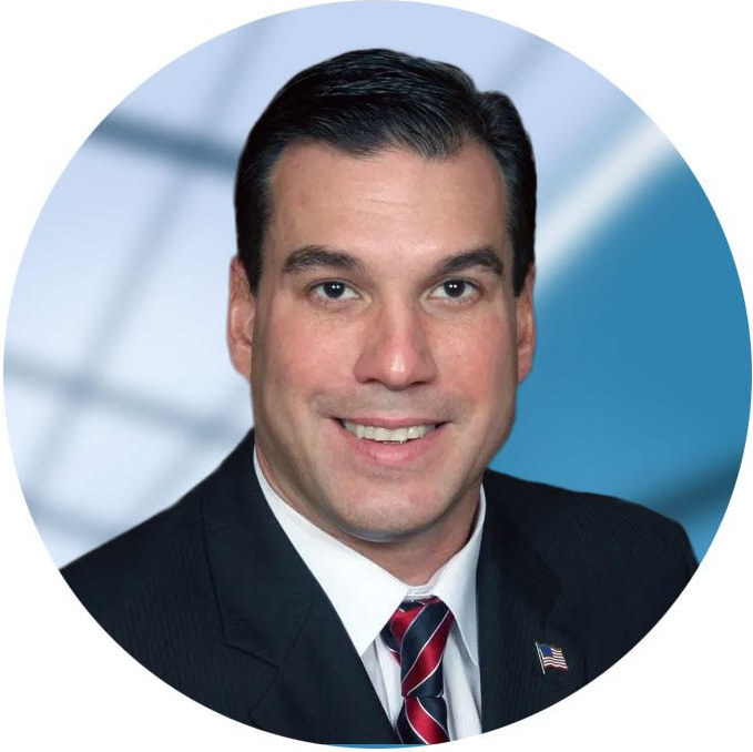A man in a suit and tie is smiling for the camera