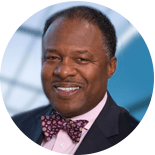 A man in a suit and bow tie is smiling in a circle.