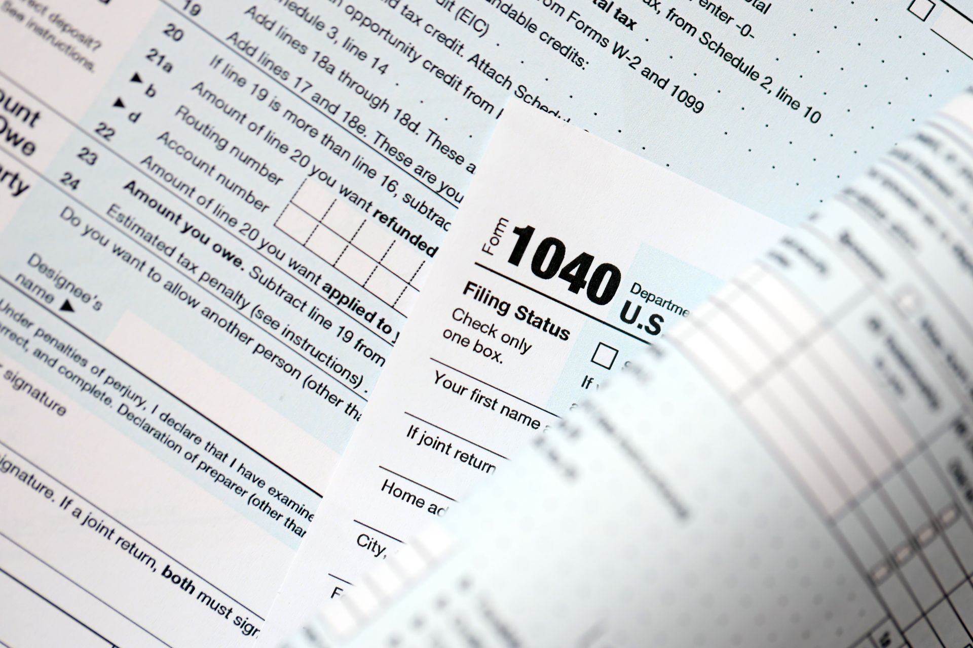 Close-up of a 1040 U.S. tax form with a calculator and paperwork underneath
