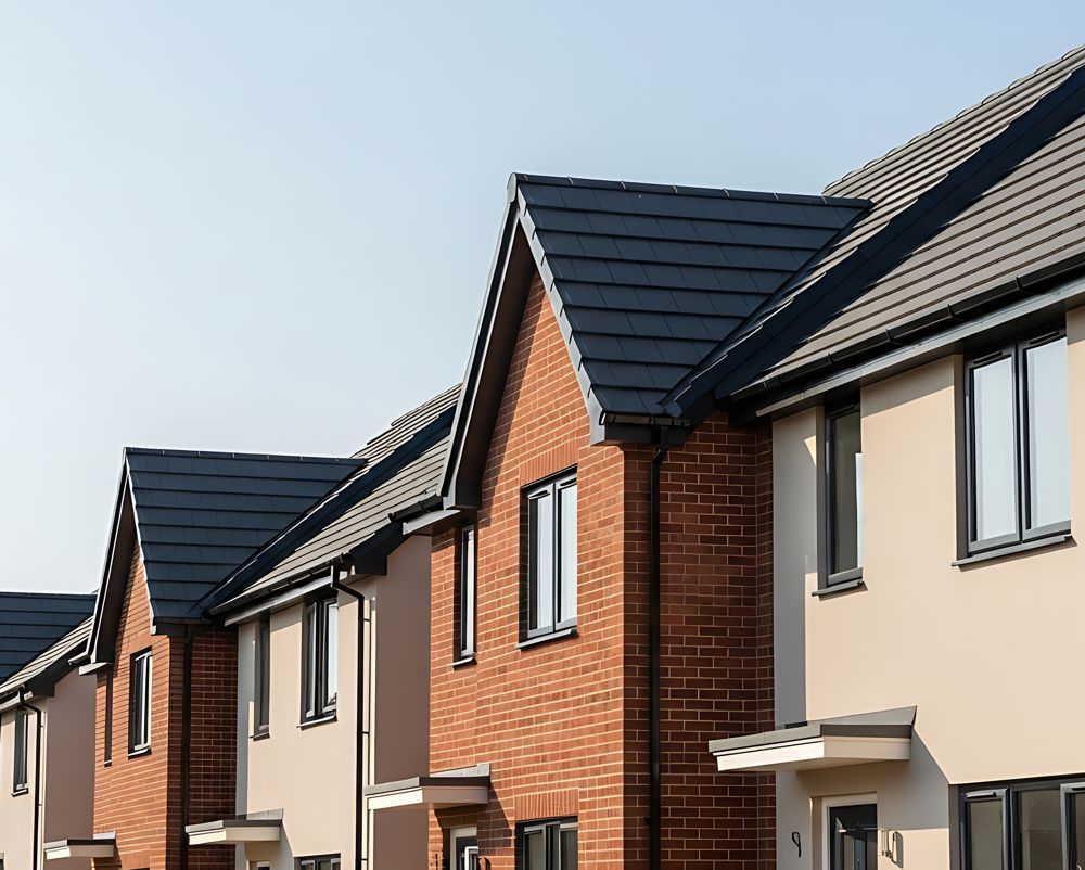 Row of modern brick-and-cream houses with dark gray roofs on a sunny day