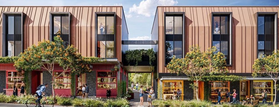 Modern storefronts with tall windows, vertical wood panels, and greenery in front of a narrow street.
