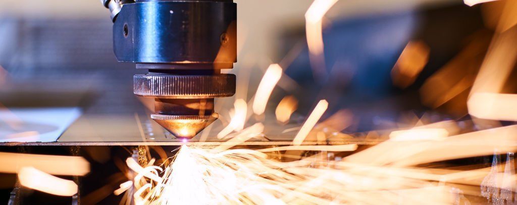 A machine is cutting a piece of metal with a lot of sparks coming out of it.
