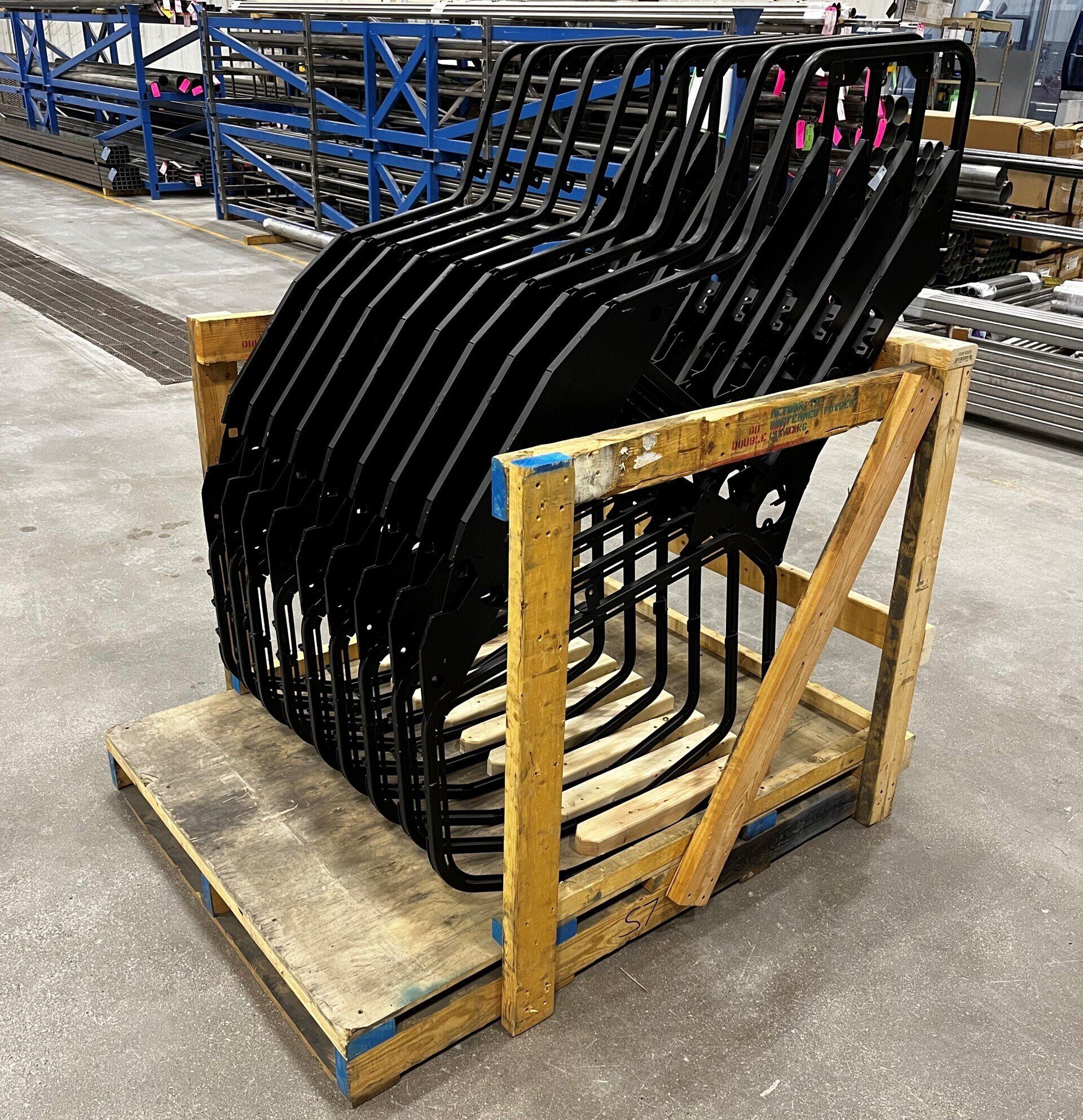 A wooden crate filled with a bunch of chairs in a warehouse.