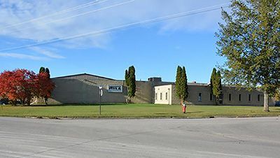 A large building with a lot of grass and trees in front of it.