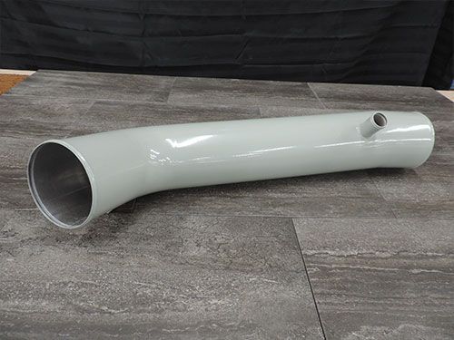 A white pipe is sitting on top of a tiled floor.