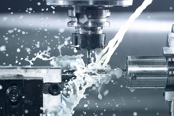A machine is cutting a piece of metal with liquid coming out of it.