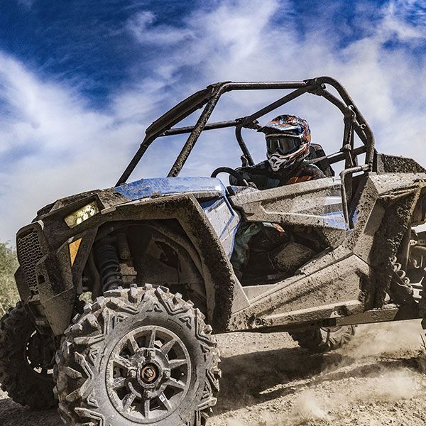 A person is riding an atv on a dirt road.