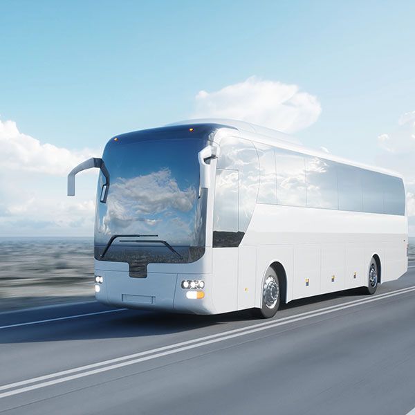 A white bus is driving down a highway.