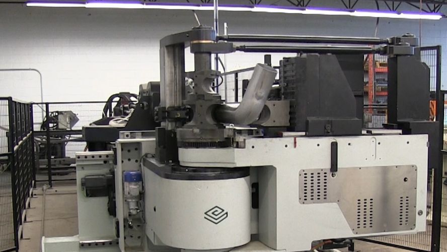 A large machine is sitting in a room in a factory.