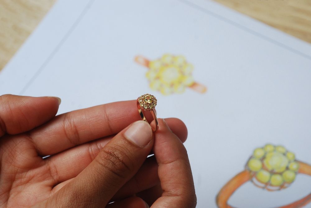 A person is holding a gold ring in their hand