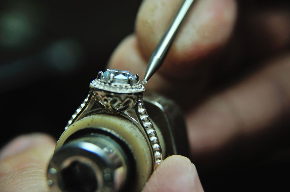 A person is working on a ring with a tool