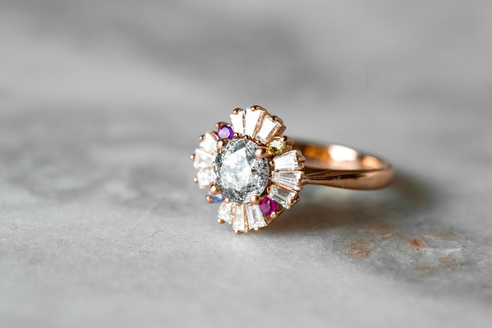 A close up of a ring with a diamond in the center on a table.