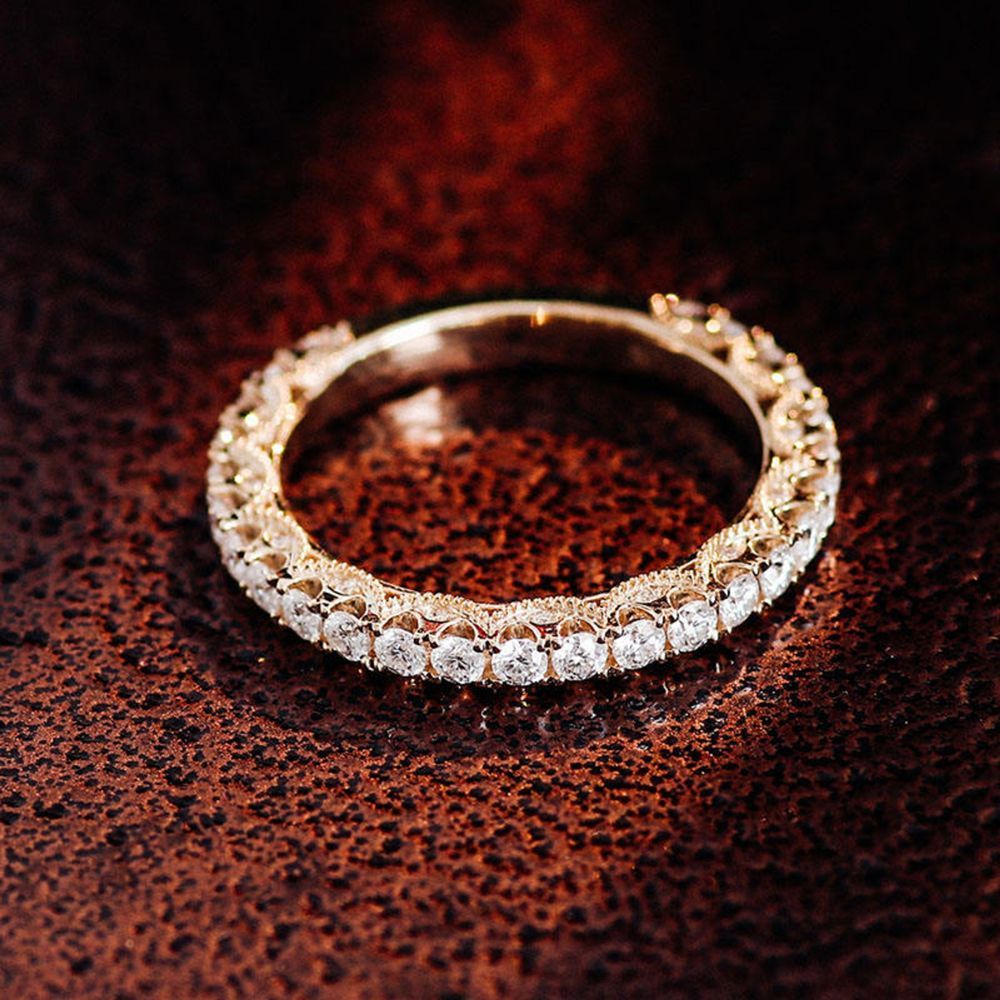 A gold ring with diamonds on a brown surface