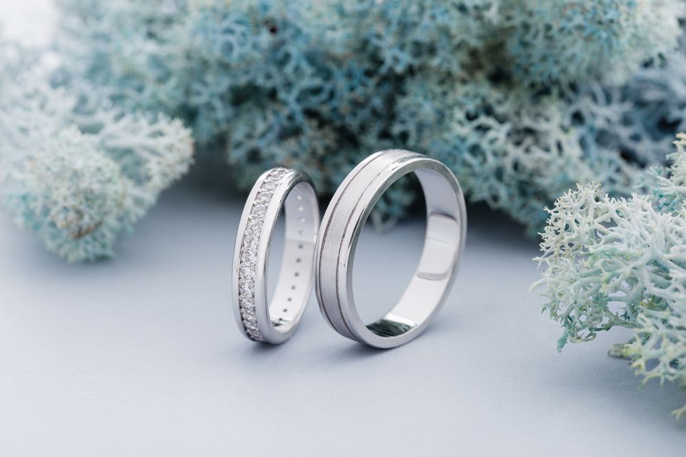 A pair of wedding rings are sitting next to each other on a table.