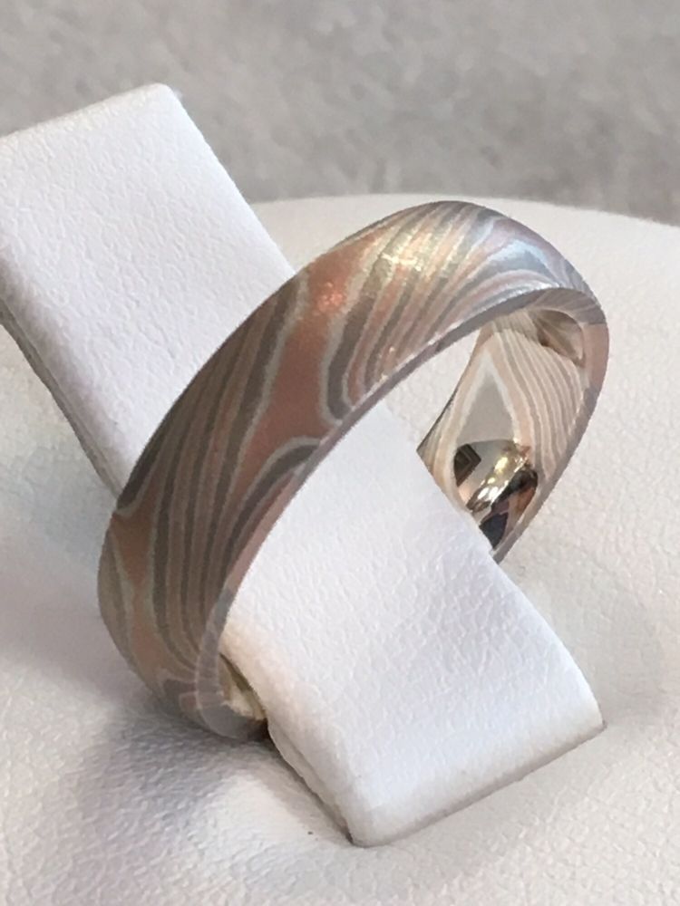 A ring is sitting on top of a white cushion.