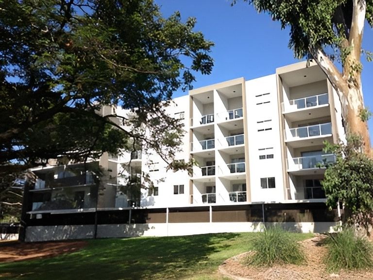 A Building With A Lot Of Balconies Is Surrounded By Trees — Mascrete Pty Ltd In Hermit Park, QLD