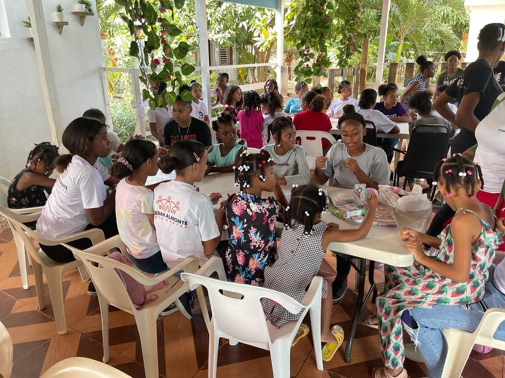 A group of children are sitting at tables eating food.