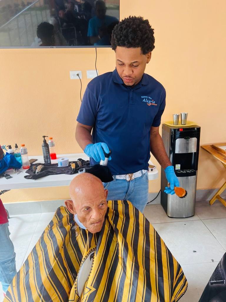 A man is cutting a man 's hair in a barber shop.