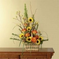 Sunflower and autumn flower arrangement in a glass vase on a wooden table