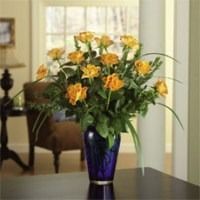 Bouquet of orange flowers in a blue vase on a dark table in a living room