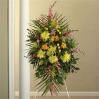 Colorful floral arrangement with yellow and pink flowers on an easel indoors