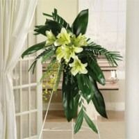 White and pale yellow floral arrangement on a stand in a bright room
