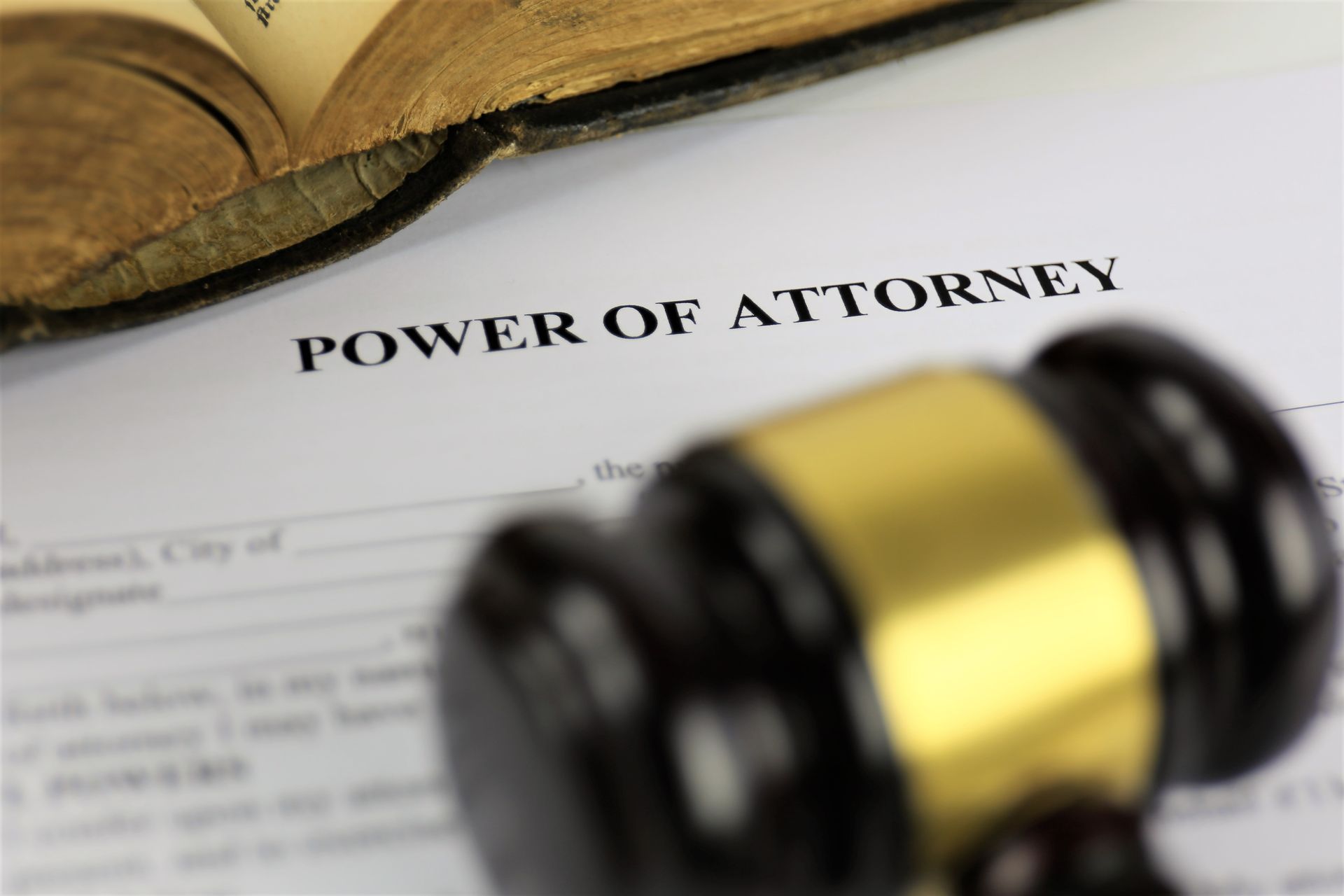 Power of attorney document with a judge’s gavel and open book in the background