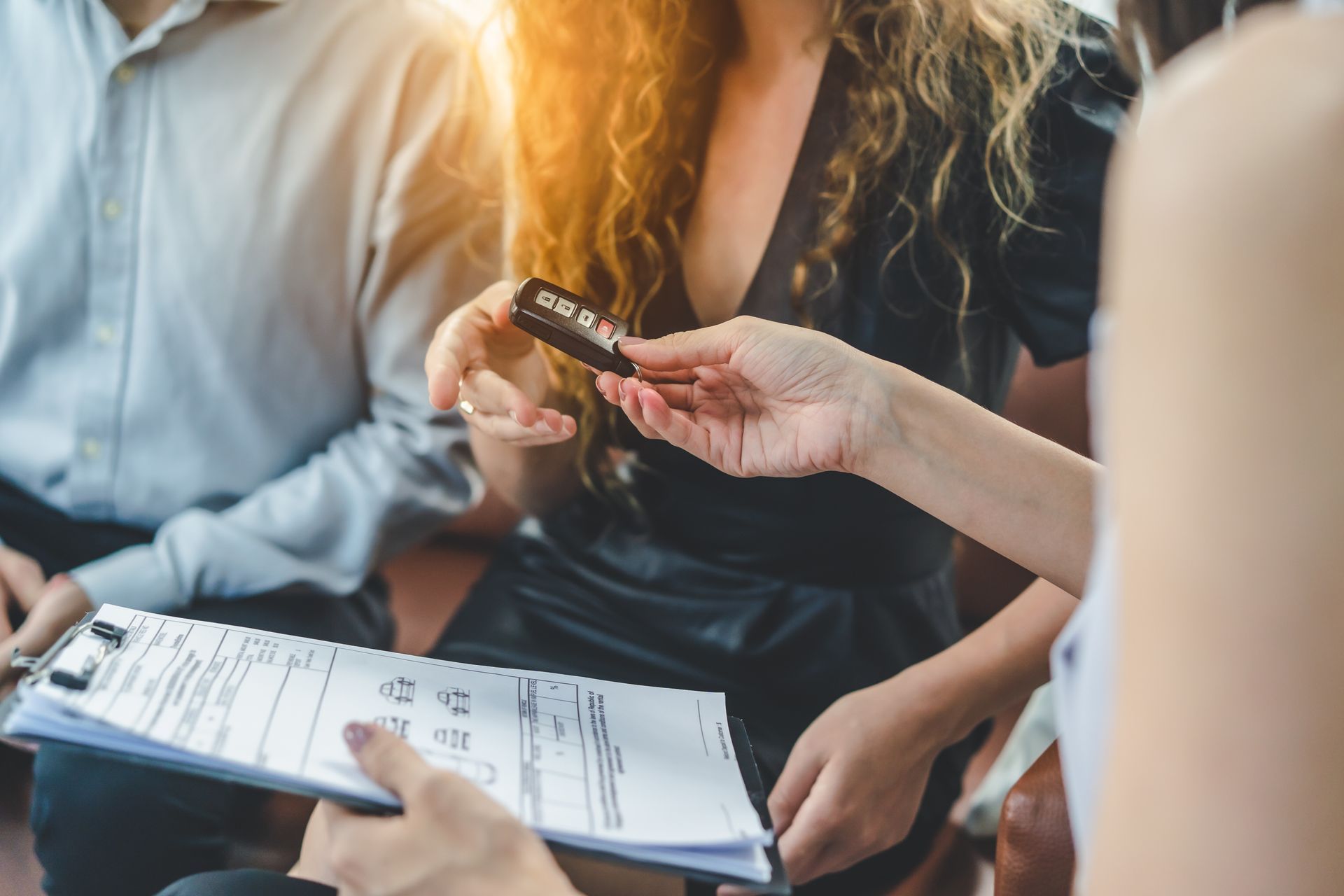 Hands holding a credit card and clipboard during a financial discussion on a couch