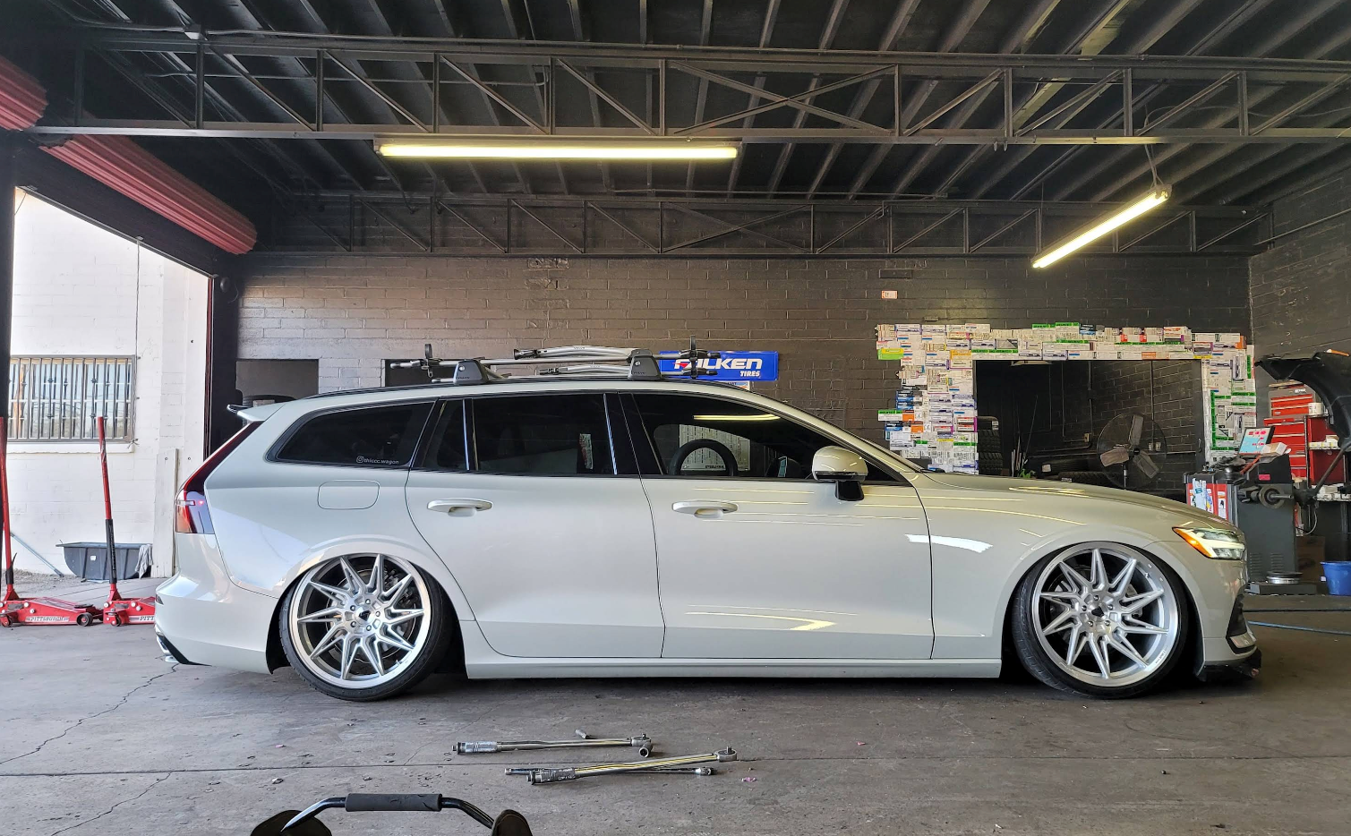 White lowered station wagon with chrome wheels parked in a garage | TireUp Tires| Wheel Alignment, Brakes & Service