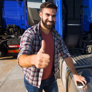 Smiling man in plaid shirt giving a thumbs-up beside a blue truck
