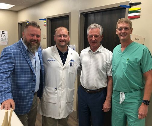 A group of doctors and nurses are posing for a picture in a hospital.