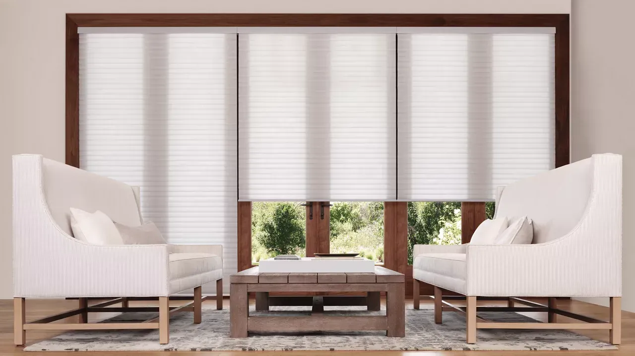 Modern living room with white chairs, wooden coffee table, and large window blinds