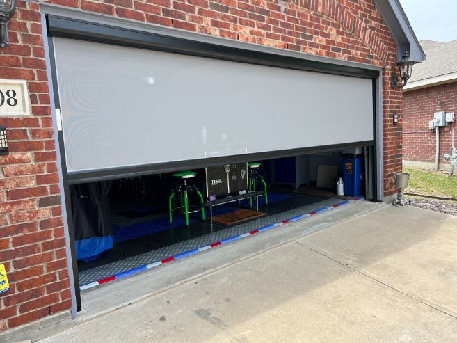 Partially open garage door revealing a dark garage with bicycles inside