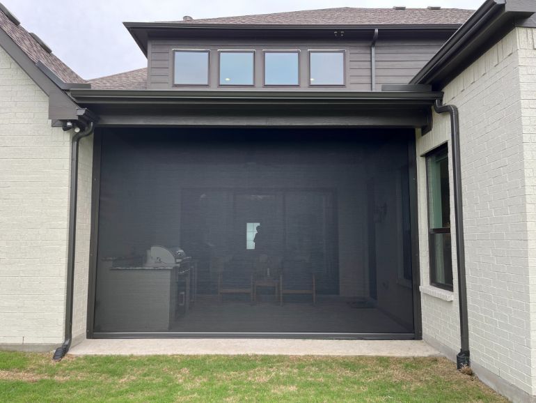 Modern house exterior with a large screened patio opening and a row of windows above