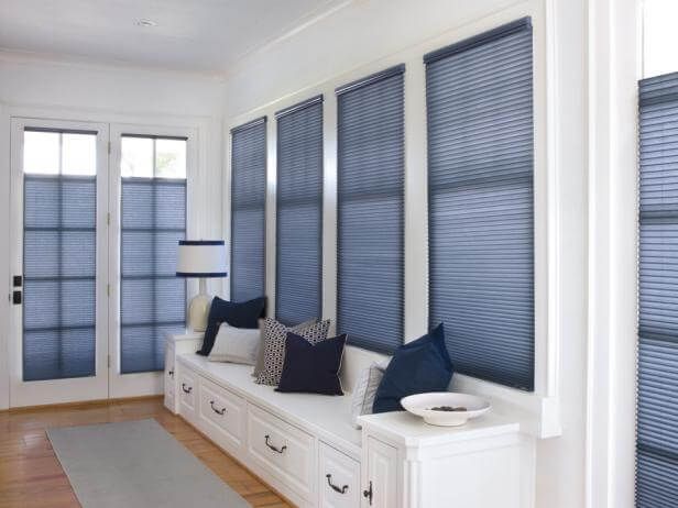 Bright sunroom with blue blinds, white daybed, and French doors
