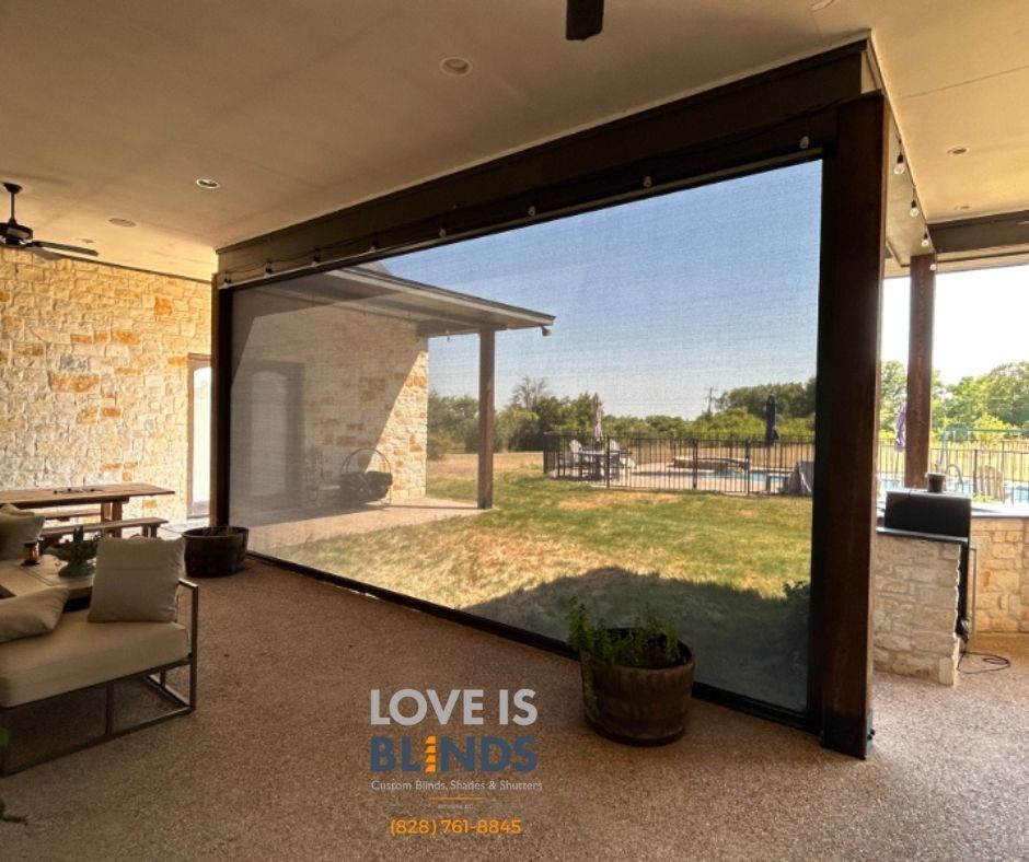 Patio with a large retractable screen framing a sunny courtyard and building beyond