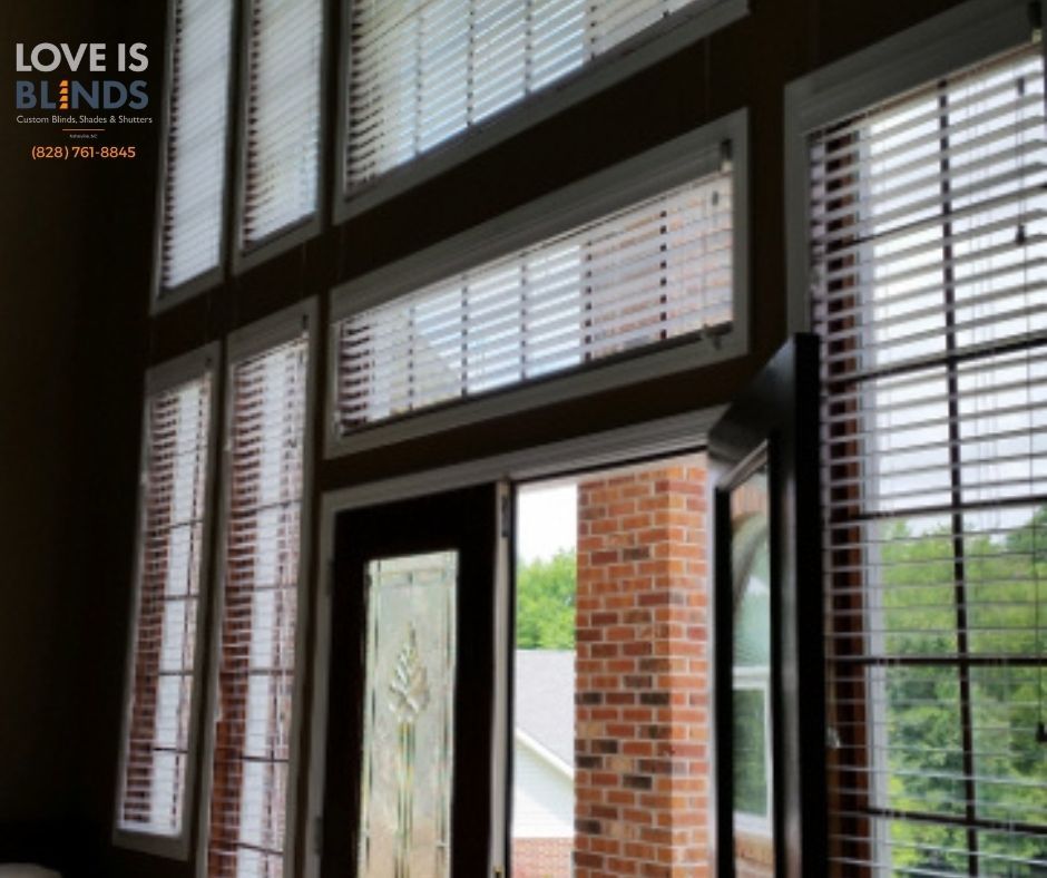 Interior window with white blinds and an open door showing a brick patio outside; 