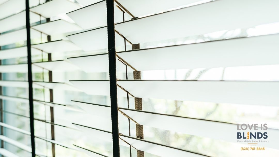 White window blinds with sunlight, and text reading “LOVE IS BLINDS.”