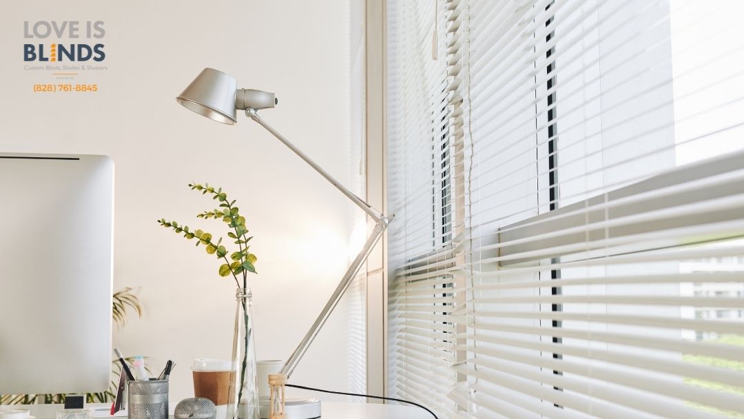 Bright white room with desk, floor lamp, vase of flowers, and window blinds; “Love Is Blind” text in corner