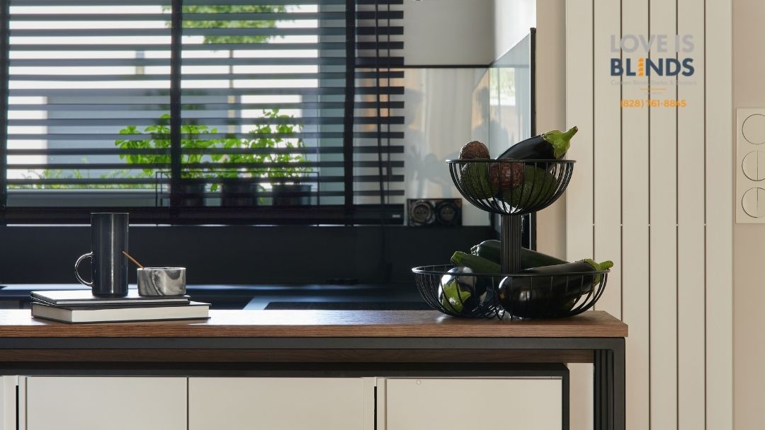 Modern kitchen with dark cabinets, wooden island, black bowls, and striped window blinds