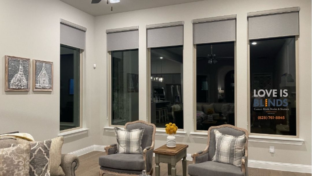 Cozy living room with two armchairs, large windows, and wall art reading “Love is…”