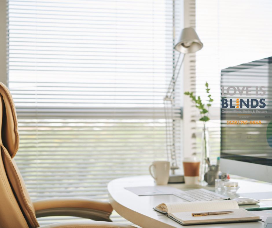 Bright home office with window blinds, white desk, chair, lamp, and a magazine rack.