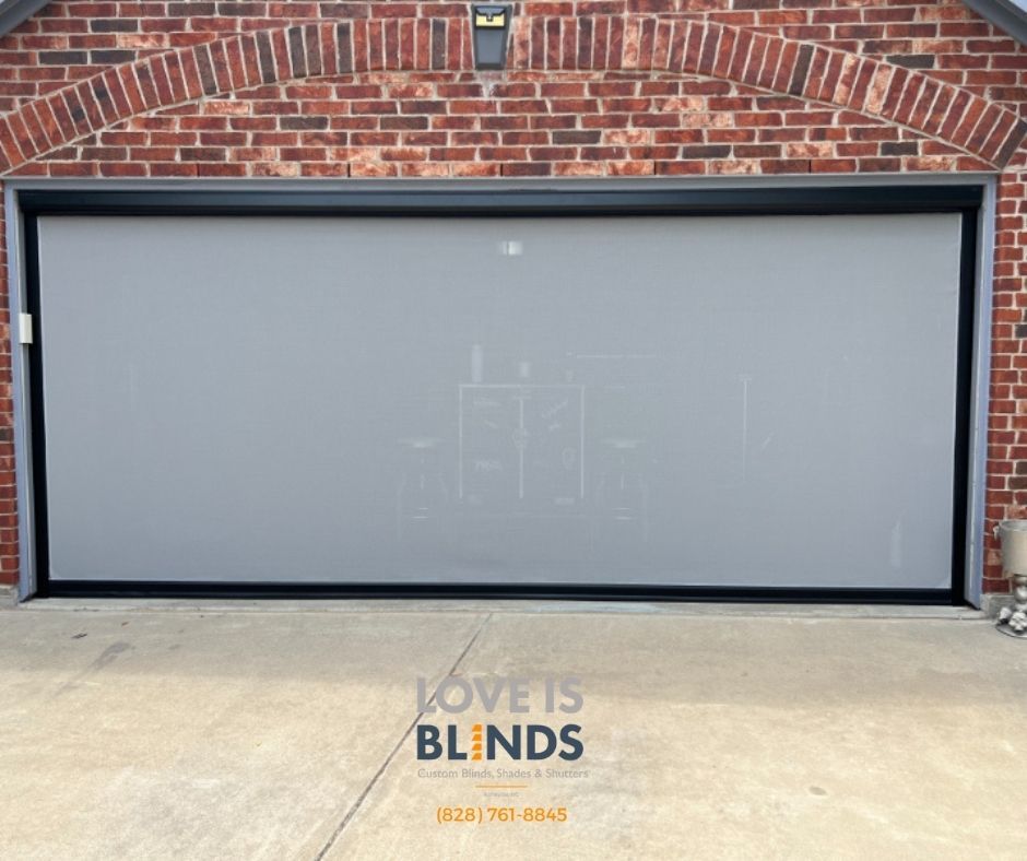 Closed gray garage door on a brick building with a black frame